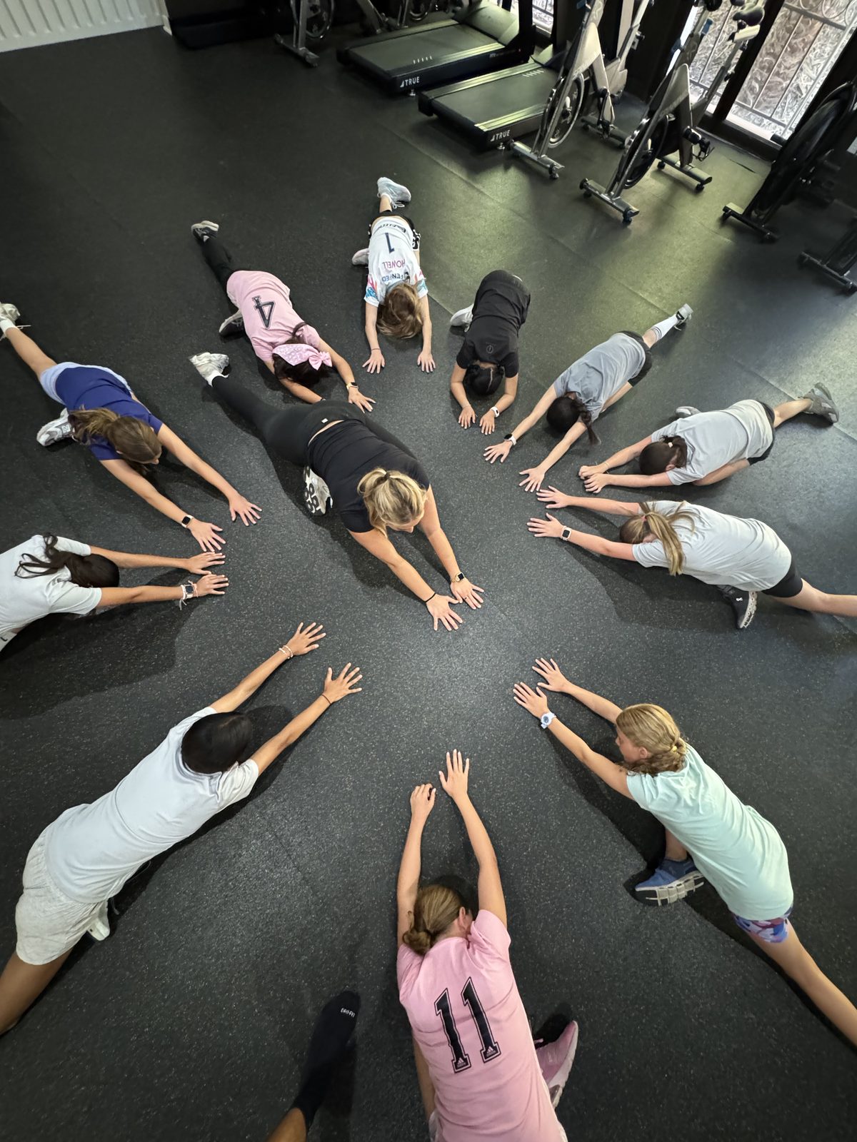Group of youth athletes in plank position at The Studio by Catalyst